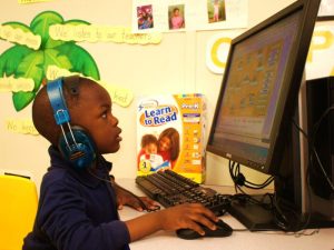 Photo of child at desktop computer.